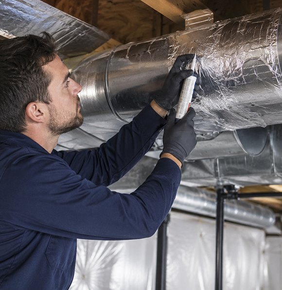 HVAC technician sealing air ducts for improved energy efficiency